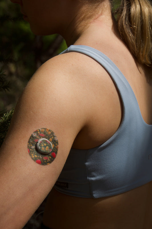 CGM patch on upper arm . Australian native florals on green backgroundDevice Dexcom G7 device.