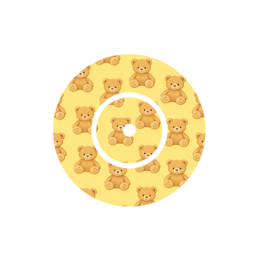 Circular design with teddy bear pattern on a yellow background fits CGM FreeStyle Libre 2 device.