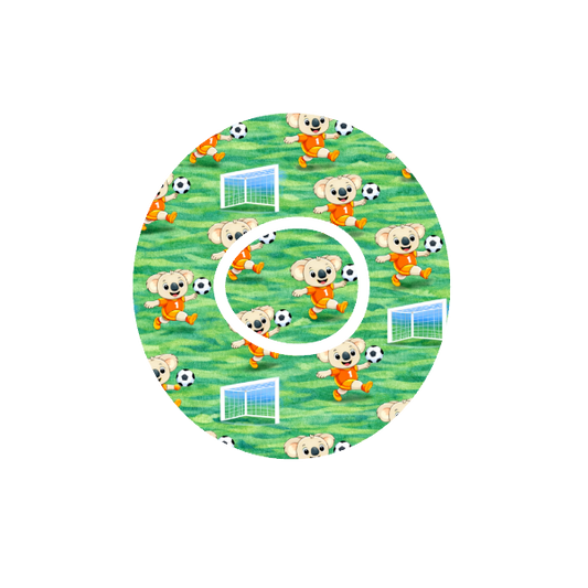 Circular design with animated Binki the koala playing soccer on a green soccer field fits CGM Dexcom One+ and G7 device.