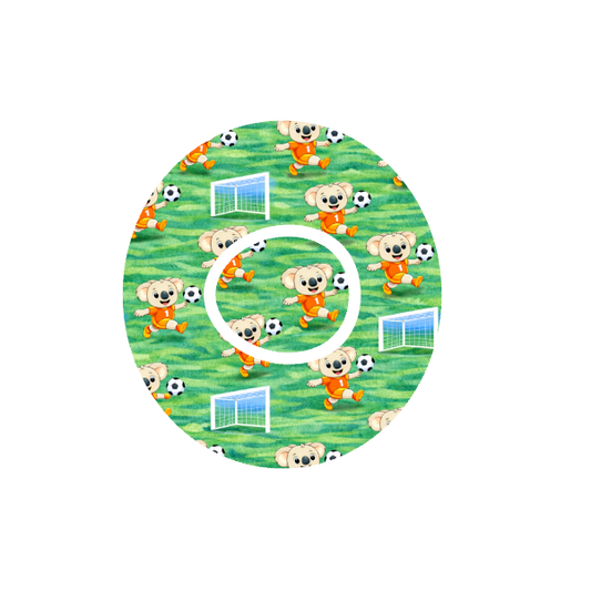 Circular design with animated Binki the koala playing soccer on a green soccer field fits CGM Dexcom One+ and G7 device.