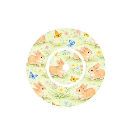 Circular shape soft animated Bunnies playing with butterflies in a meadow of flowers with a cream background fits CGM Dexcom One+ and G7 device.