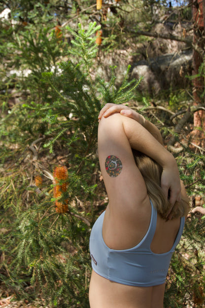 CGM patch on upper body upper arm .  Australian native florals on green backgroundDevice Dexcom One + device.