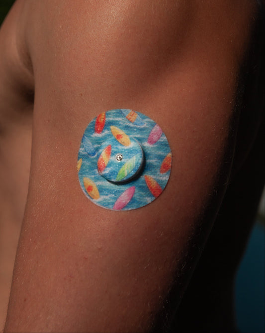 Surfboards CGM patch worn on upper arm for FreeStyle Libre 2 — colourful surfboards on blue waves
