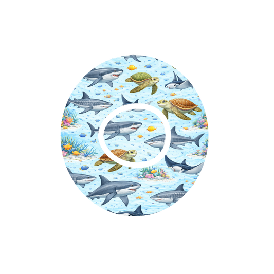 Circular design underwater scene with sharks, rays and turtles swimming on a blue background. Fits Dexcom One+ and G7 device.
