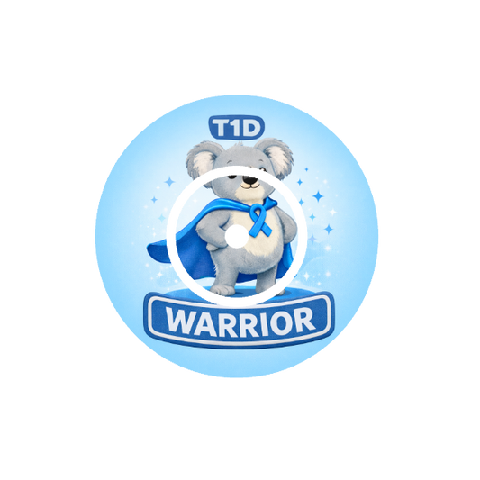 Circular shape animated Binki the koala a character with a blue cape and ribbon, labeled 'T1D Warrior' on a light blue background fits CGM FreeStyle Libre 2 device.